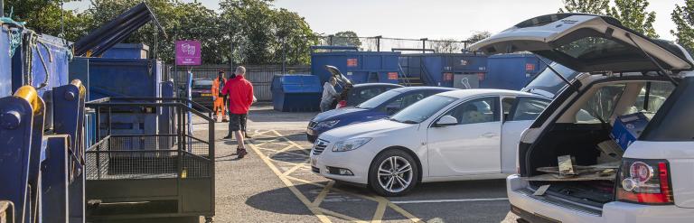 People disposing waste at a household waste recycling centre