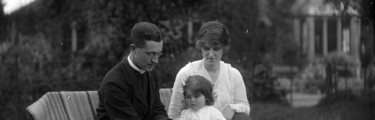 Jim, Eva and a child named as Nancy, reading in a garden at Lower Dunsforth in August 1917. 