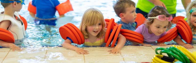 A group of children in armbands learning to swim