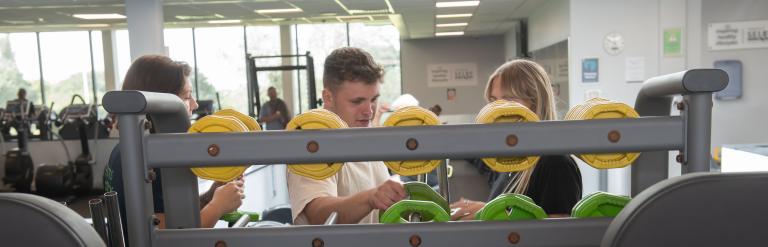 One of our fitness instructors shows a new member our gym equipment