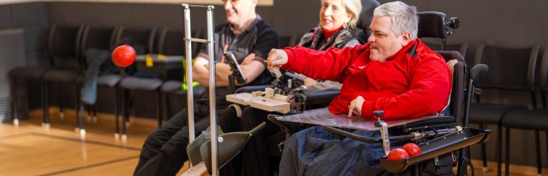 A man throwing a boccia ball as part of a game at Fairfax Community Centre
