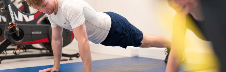 Two people doing press-ups among the gym equipment at Ripon Leisure and Wellbeing Hub - The Jack Laugher Centre