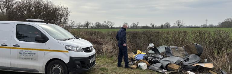 An enforcement officer looking at fly-tipping