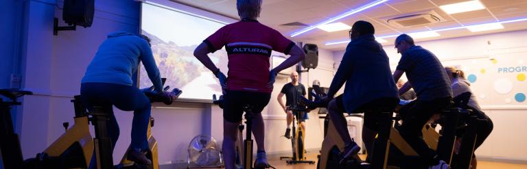 A group take part in a spinning class.