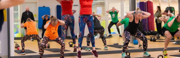 A group of people taking part in an exercise class at Northallerton Leisure and Wellbeing Hub, some people are squatting, some are jumping