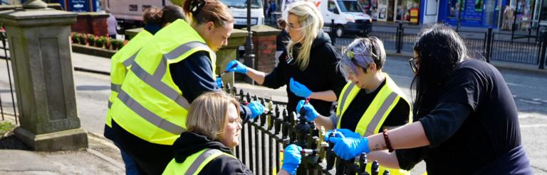 Group of people in Scarborough painting metal fencing