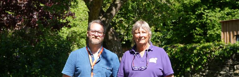 Two adults standing outside smiling at the camera