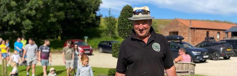 Farmer Percy walking in the sunshine followed by families. Credit Darren Barnett and Studio41