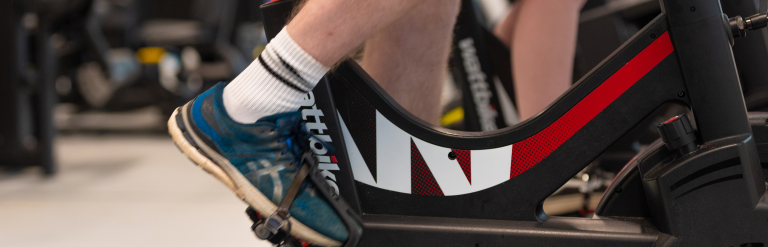A close up of feet on the pedals of a stationary bike.