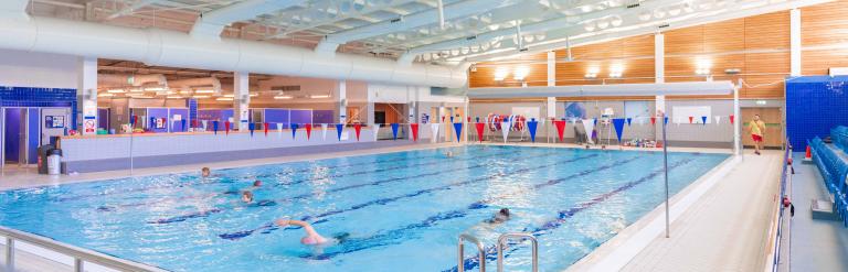 A view of Skipton Leisure and Wellbeing Hub swimming pool, several people are swimming