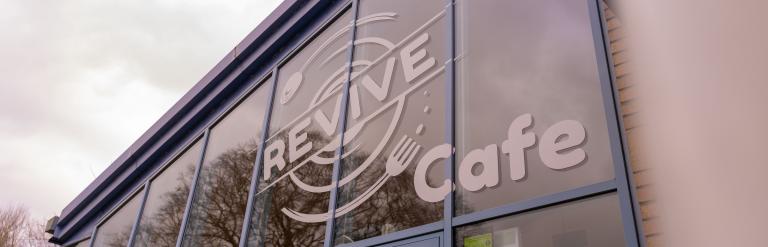 The Revive Cafe sign on the glass front of the building.