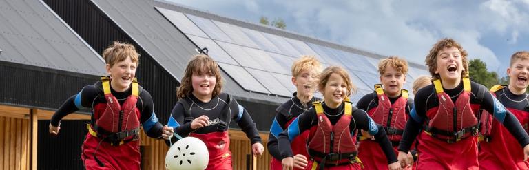 Group of children running and smiling at Bewerley Park outdoor education centre