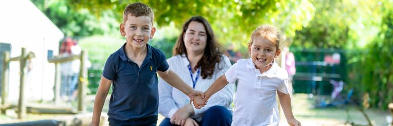 Olha Honcharuk pictured with her two children who are running towards the camera holding hands